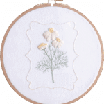 Chamomile flowers embroidery kit with yellow and white floral embroidery in a wooden hoop