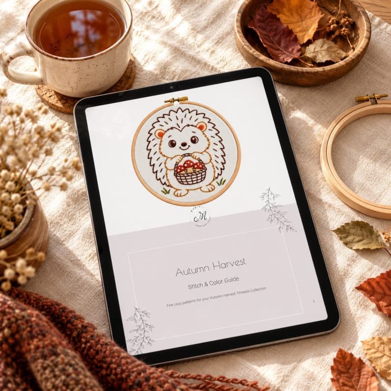 Autumn embroidery patterns: tablet showing the Autumn Harvest Stitch & Color Guide PDF cover, next to a cup of tea